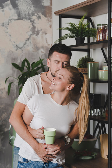 man-hugging-her-girlfriend-holding-cup-coffee.jpg