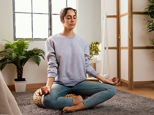 front-view-young-woman-meditating-home.jpg