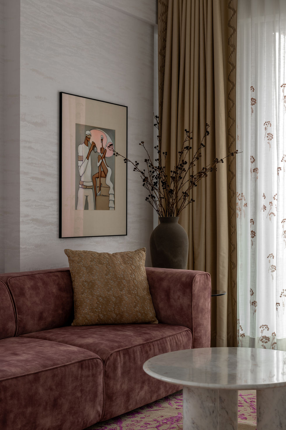 Framed artwork above a sofa with decorative vase.
