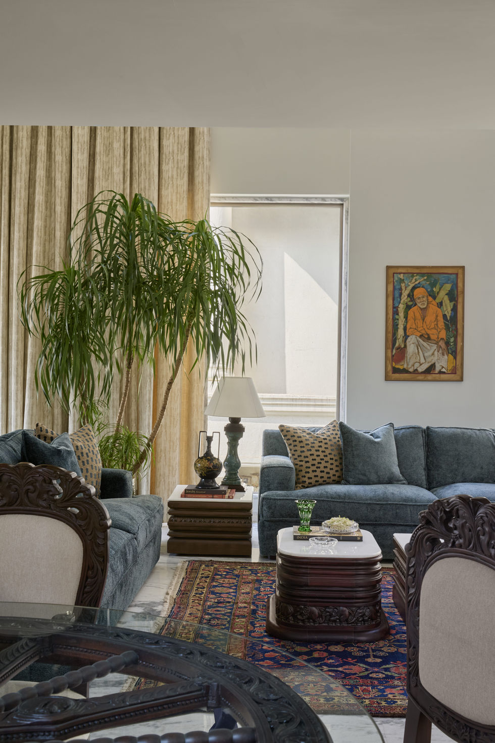 Elegant living room with sofas, plant, and artwork.