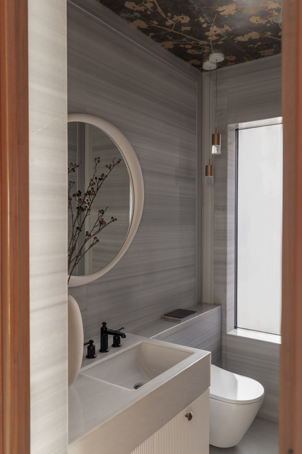 Modern bathroom with round mirror and minimalist design.