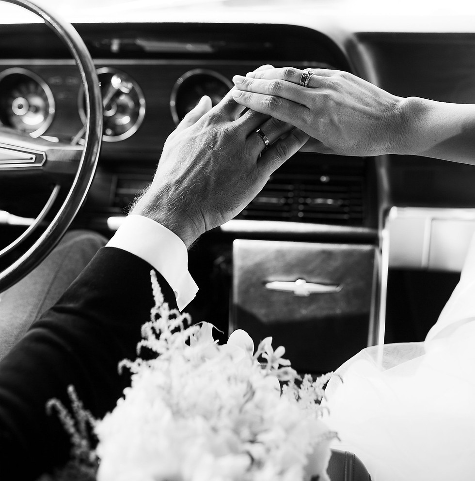 Close-up of newlyweds holding hands in a car after their wedding ceremony.jpg
