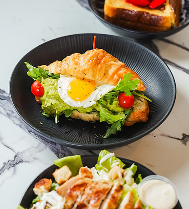 Croissant sandwich with fried egg and grilled chicken salad