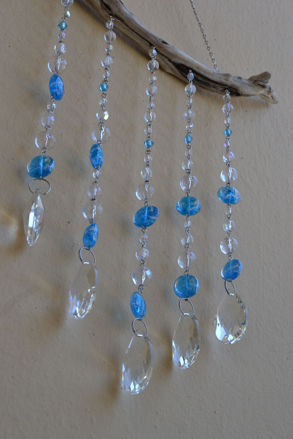 Close-up of blue Czech glass beads and crystal drops on handmade driftwood wall hanging