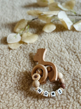 Zachte bijtring voor dreumes Nowi in beige en choco met blaadjesprint kraal en daisy. Houten giraffe figuurtje erbij.