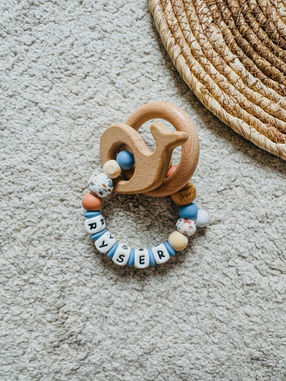 Bijtring voor Ryser met zeedierenkraal, walvis en kralen in koraal, lichtblauw en hout. Stoer en schattig babycadeau.