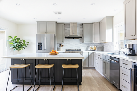 Spacious open-concept kitchen with light grey perimeter cabinets, a contrasting dark charcoal kitchen island, white quartz countertops, and stainless steel appliances