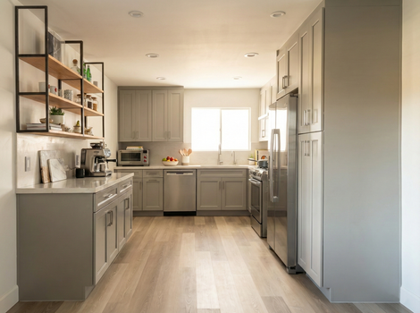 Modern kitchen featuring grey shaker cabinets, light wood flooring, and industrial-style wood and metal open shelving.