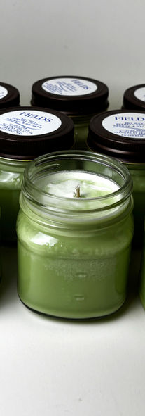 10 candles in jars. three in front have lids removed. showcasing the wax, jars and lids. 