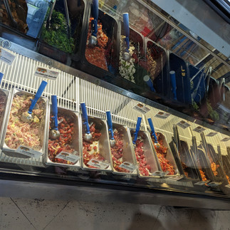 Poke bar with multiple types of poke shown behind glass at restaurant