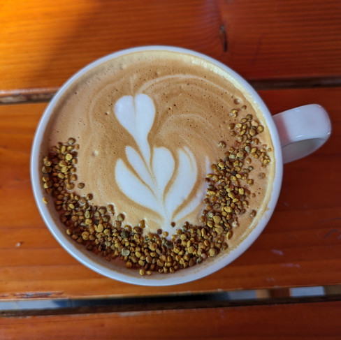 latte with foam art and bee pollen on top