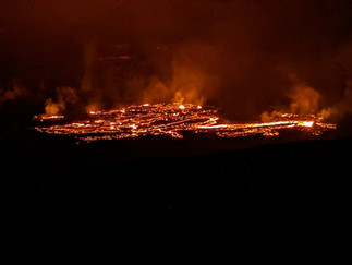 night time landscape shot of the active lava flow from above and at a distance