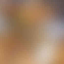 two glasses of red wine sit atop a table, with a plate of crackers and cream cheese dip inbetween the glasses.