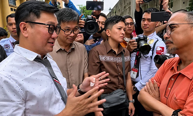Si DOLE Secretary Francis Tolentino si Atty. Luke Espiritu, lider ng grupong Buklurang Manggagawang Pilipino (BMP) sa kalagitnaan ng kilos-protesta sa harap ng tanggapan sa Maynila kaugnay sa pagpapatigil ng Pasig RTC sa P85 umento o karagdagang suweldo.