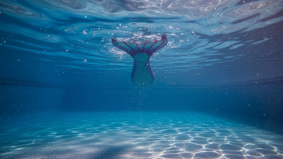 Eye-level view of a swimming pool with a mermaid tail floating on the water