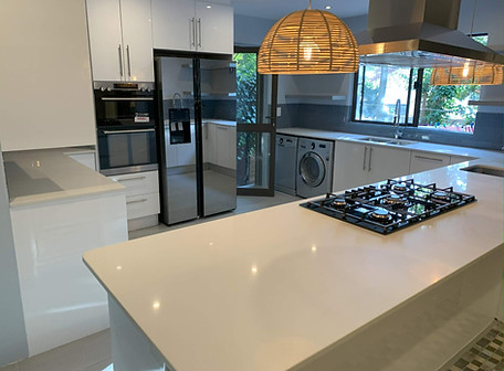 Modern white kitchen renovation in Rivonia
with quartz island countertop and built-in gas hob by FBA Projects
