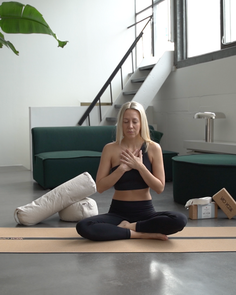 Julia C Wollner hat die Hände auf der Brust verschränkt und die Augen geschlossen