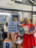 happy book company illustrator tessa cobb in front of bologna book fair stand holding children's picture books