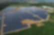 Aerial view of the expansive AES Illumina PV Solar Farm, showcasing rows of gleaming solar panels strategically positioned in 2011, highlighting its 20 MWAC capacity and 38kV interconnection amidst natural surroundings.