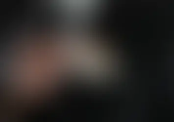 Businessman placing a small model house into his suit pocket.