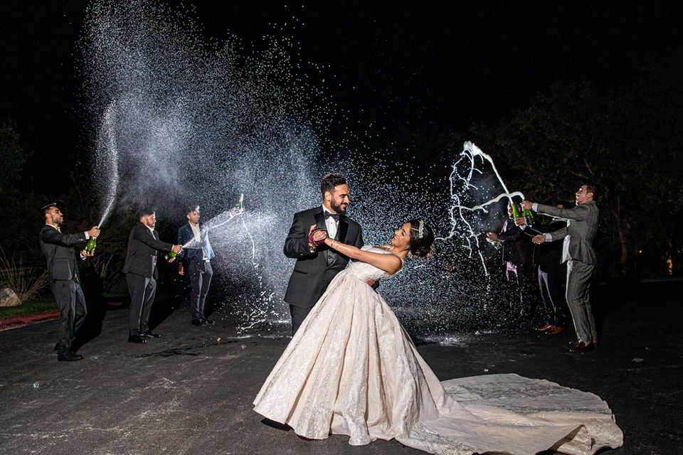 Newlyweds dancing and guests are cheering