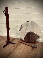 Native American Flute zusammen mit einer Schamanentrommel, im Hintergrund eine weiße Steinwand