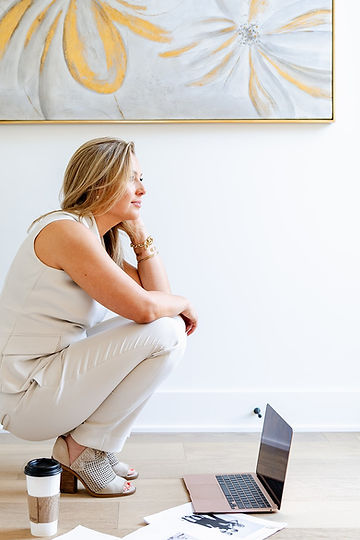 Danielle sitting on the floor next to her laptop and coffee