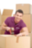 A male in a purple We Care Affordable Moving shirt packing moving boxes.