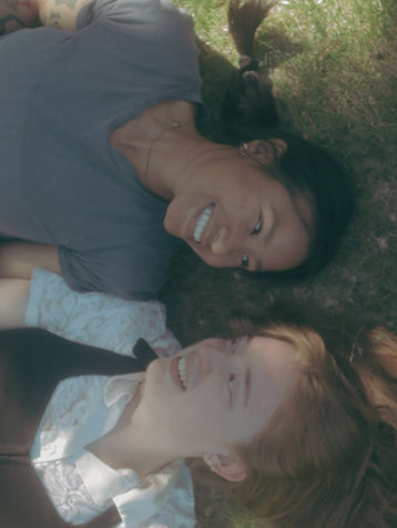 two women lying down and smiling at each other
