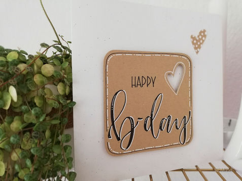 Geburtstagskarte mit Text: happy b-day! auf Kraftpapier und einem ausgestanzten Herzen.