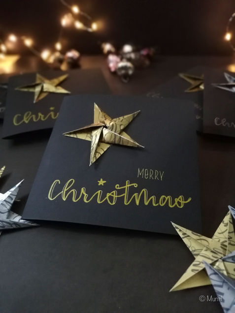 Weihnachtskarte mit goldenem Stern auf schwarzer Karte mit Text Merry Christmas.