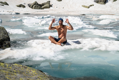 Homme torse nu assis sur la glace