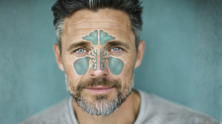 Close-up of a middle-aged man with a medical illustration overlay showing inflamed sinus cavities around the nose, forehead, and cheeks, highlighting areas affected by sinus pressure and congestion.