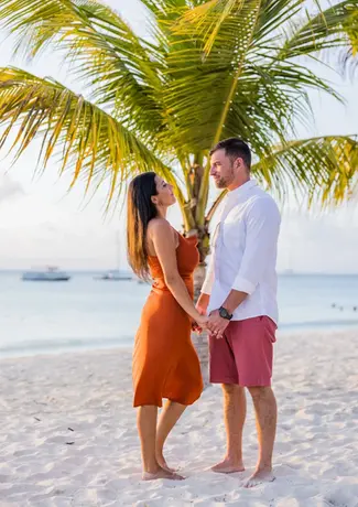 Couple posing on the beach, captured by a wedding photographer and videographer.