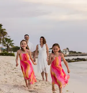 A smiling family poses on the beach during a photo shoot in Aruba, capturing special moments in a paradisiacal setting. Ideal for family portraits and family photo studios