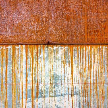Rusted panel dripping onto clean metal