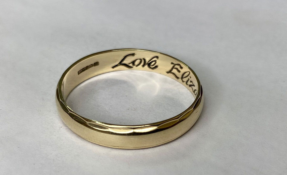 A wedding ring engraved with the words Love Eliza