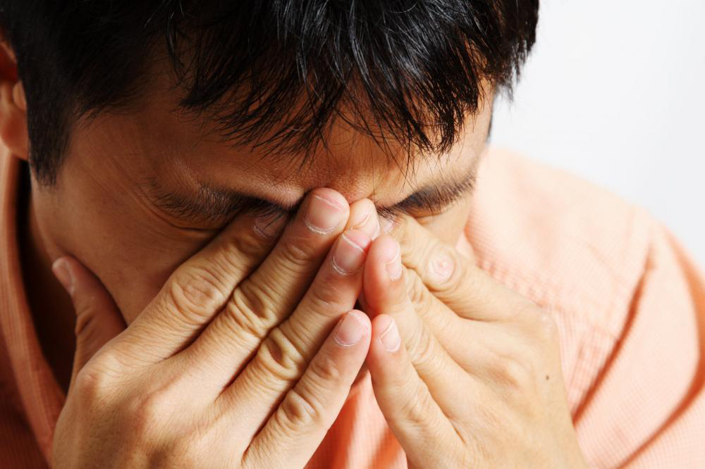 A stressed out man having a headache.