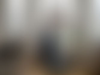Une femme s’affaire à nettoyer les grandes vitres de son salon.
