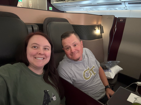 Two people sitting in business class on Qatar Airways