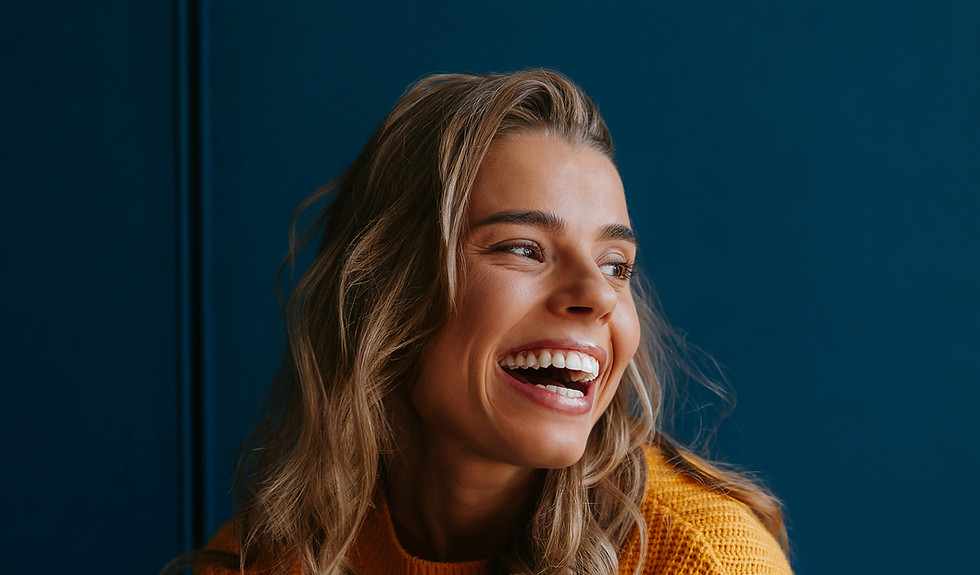 happy-young-blond-hair-woman-yellow-sweater-looking-away-while-standing-blue-background
