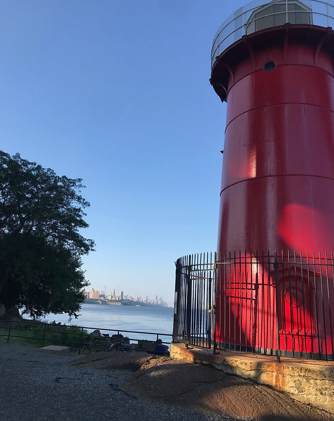 The Little Red Lighthouse NYC under the George washington bridge NY with a view of the river and blue skies