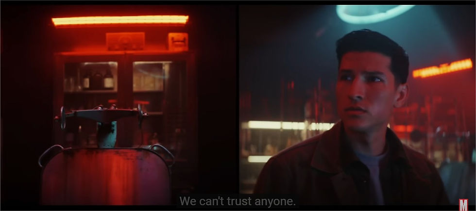 a screenshot of the trailer showing a torture chair in a red light and Joaquin in the lab