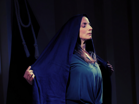 Woman standing with arms outstretched to the side with her eyes closed