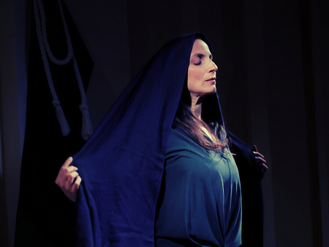 Woman standing with arms outstretched to the side with her eyes closed