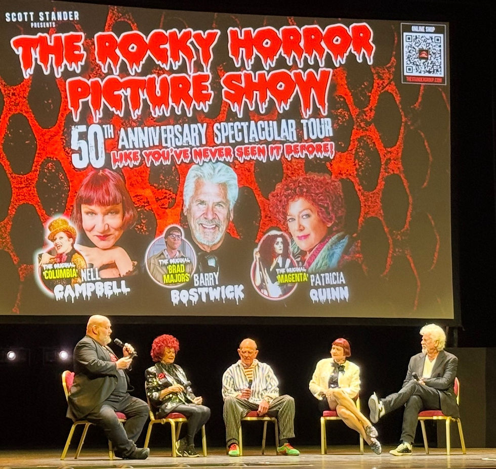 Panel of five people sitting on stage discussing "The Rocky Horror Picture Show" 50th Anniversary, with a colourful background and poster.