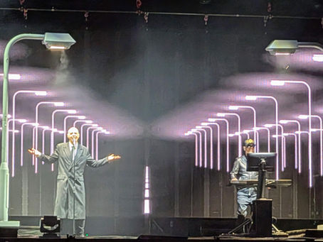 Two men on a stage with multiple images of lampposts