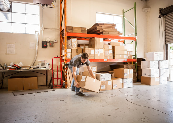 Worker Lifting Cardboard Box