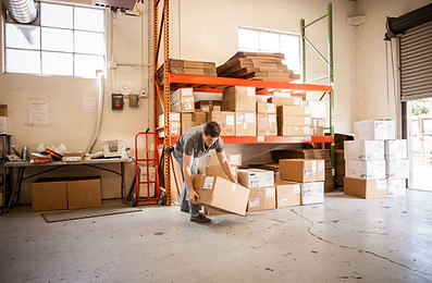 Worker Lifting Cardboard Box