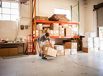 Worker Lifting Cardboard Box
